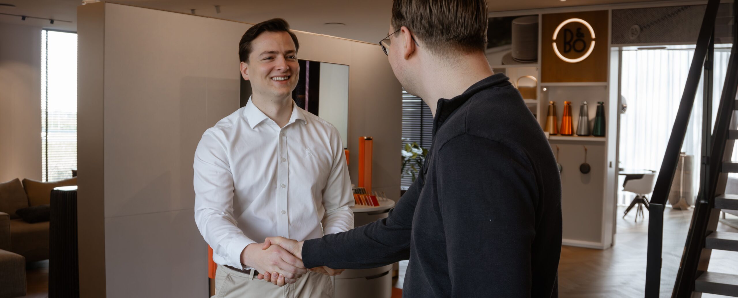 Hartelijke ontvangst van een klant in de showroom van Bang & Olufsen Henri Tibosch.