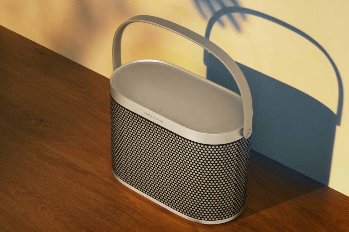 Beosound A5 in Spaced Aluminium op een houten tafel in de zon