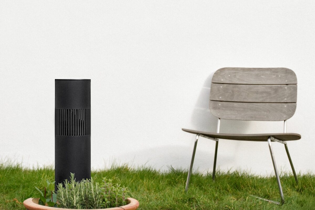 Zwarte Beosound Bollard in het gras voor een witte gevel